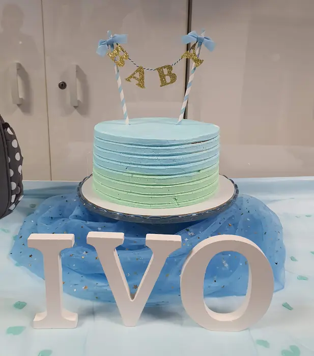 Bolo de baby shower em degradé de azul e verde com bandeirola dourada
