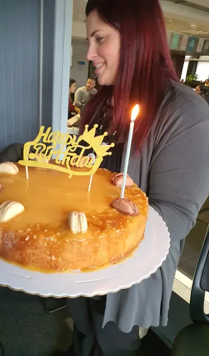 A Feli a segurar um bolo de caramelo com vela acesa